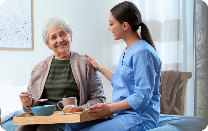 Elderly person with support worker having breakfast